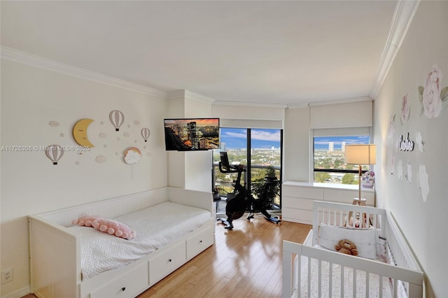 bedroom featuring ornamental molding and light hardwood / wood-style floors