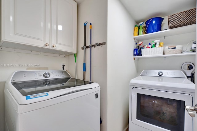 laundry area with washing machine and dryer and cabinets