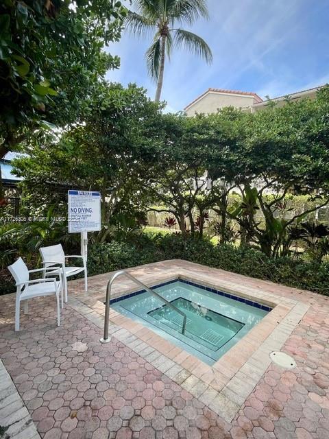 view of swimming pool with a patio area and a hot tub