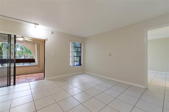 unfurnished room with light tile patterned floors and baseboards