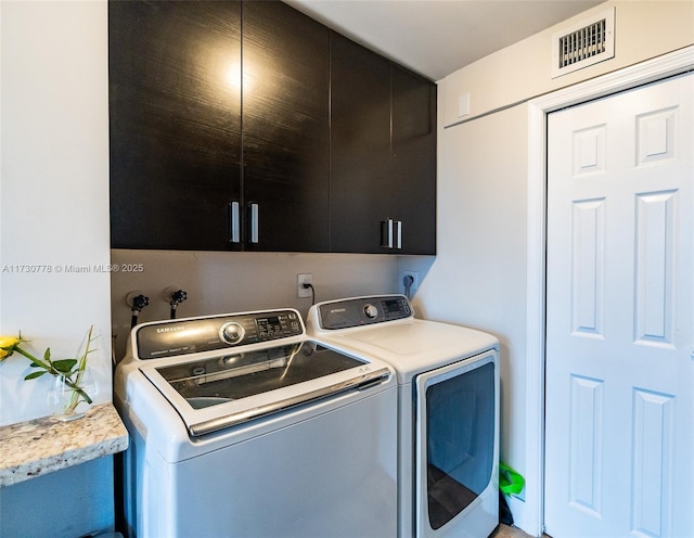 laundry room featuring cabinets and washing machine and dryer