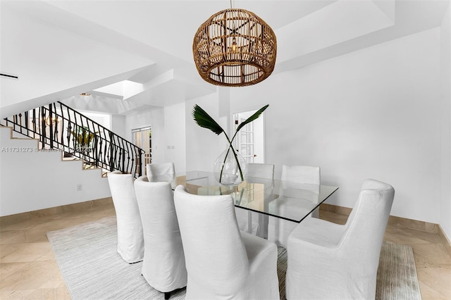 dining room with a notable chandelier and a tray ceiling