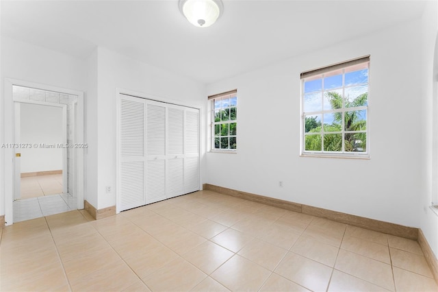 unfurnished bedroom featuring light tile patterned floors and a closet