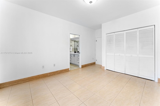 unfurnished bedroom featuring light tile patterned floors and a closet