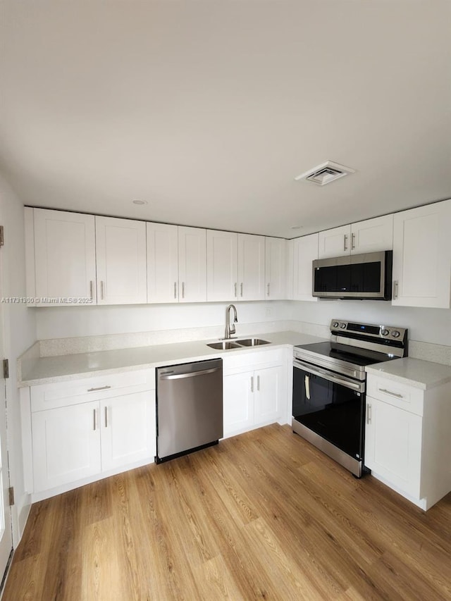 kitchen featuring white cabinetry, appliances with stainless steel finishes, and sink