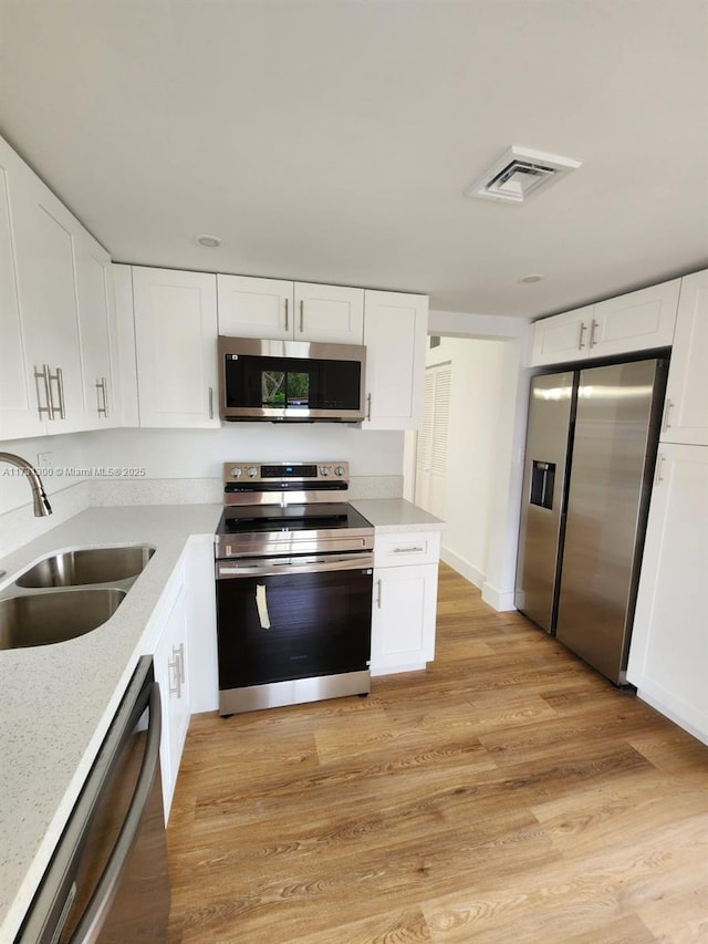 kitchen featuring white cabinetry and appliances with stainless steel finishes