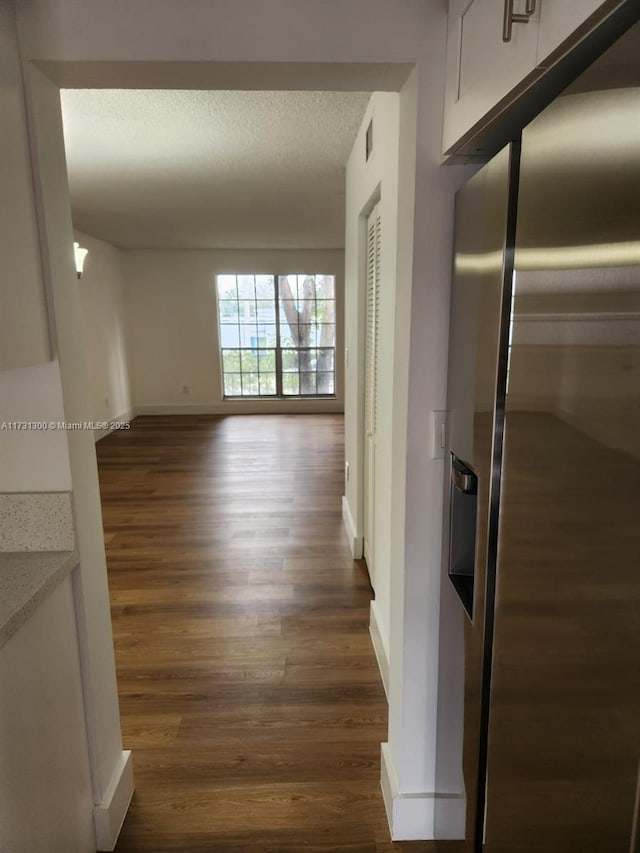 corridor featuring dark hardwood / wood-style floors and a textured ceiling