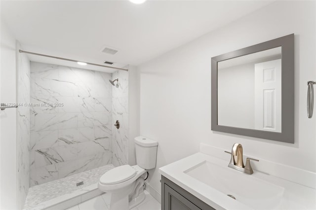 bathroom featuring vanity, toilet, and a tile shower