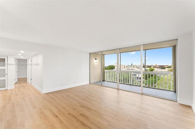 unfurnished room featuring light hardwood / wood-style flooring and floor to ceiling windows