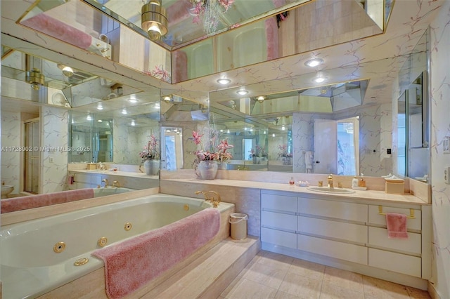 bathroom featuring tiled tub, vanity, and tile patterned flooring