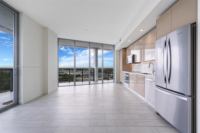 kitchen with stainless steel appliances, floor to ceiling windows, and a wealth of natural light