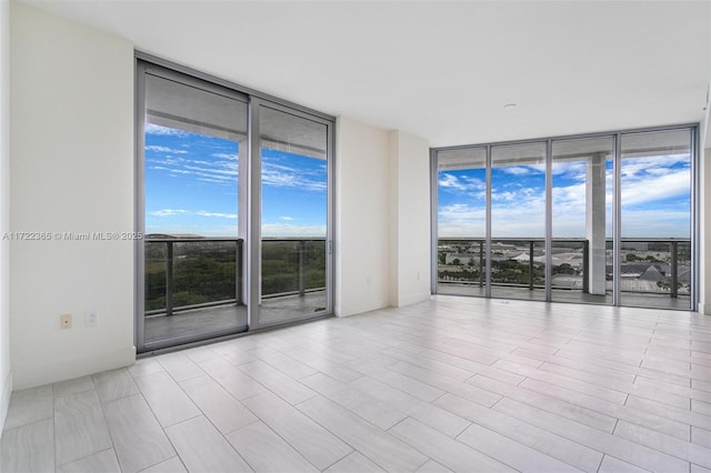 empty room with a wall of windows and baseboards