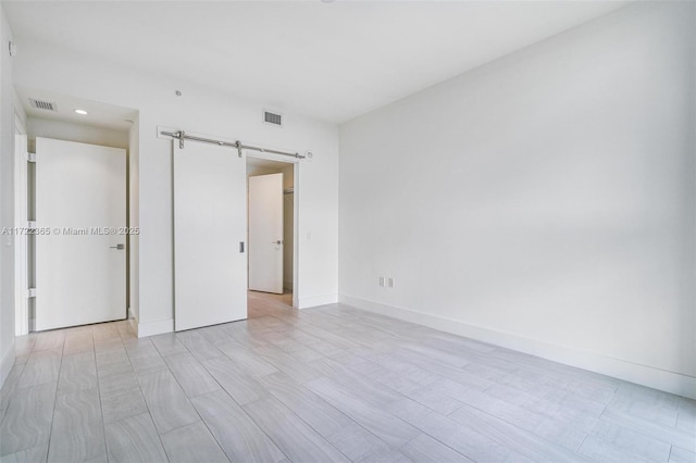 unfurnished bedroom featuring a barn door