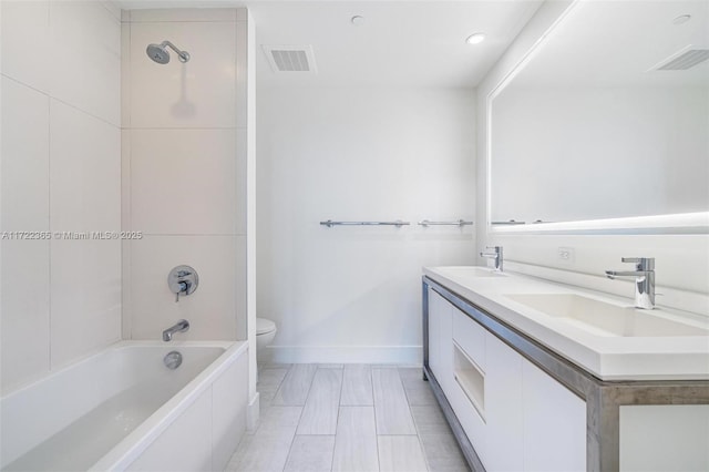 full bathroom with vanity, toilet, and tiled shower / bath combo