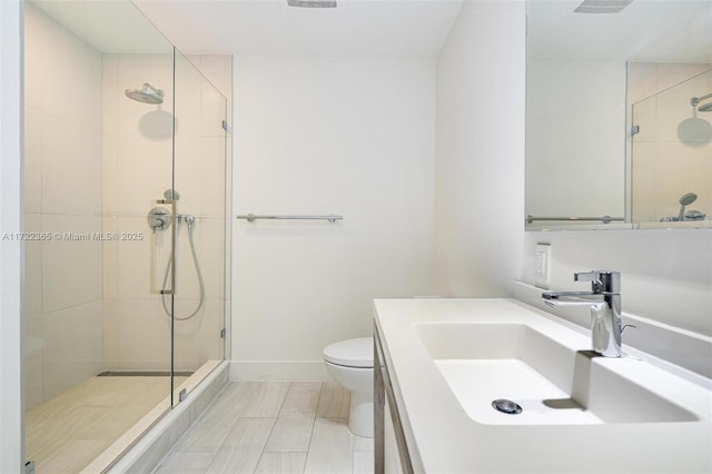 bathroom with vanity, a shower with shower door, and toilet