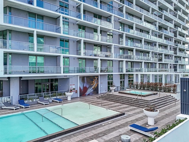 view of swimming pool with a community hot tub