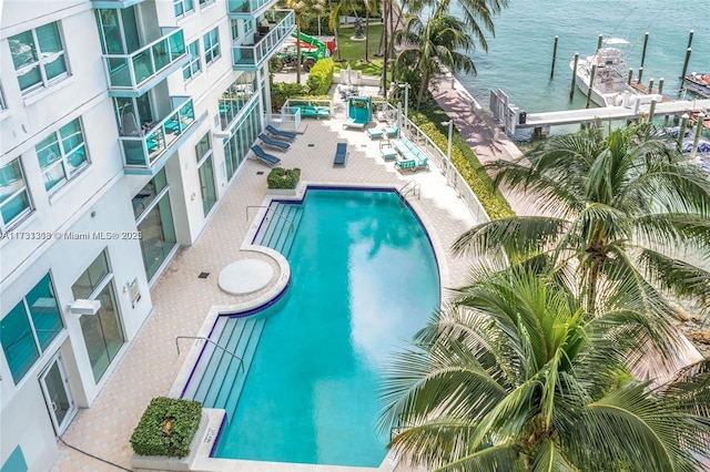 view of pool with a patio and a water view