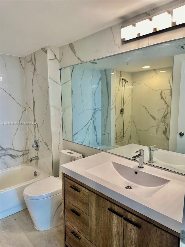 full bathroom featuring vanity, tiled shower / bath combo, and toilet