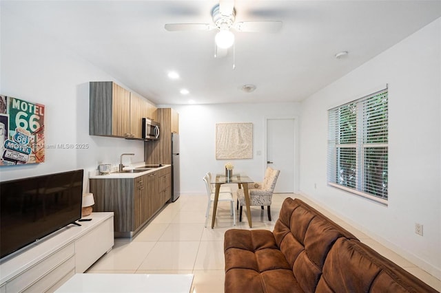 kitchen with ceiling fan, appliances with stainless steel finishes, sink, and light tile patterned floors