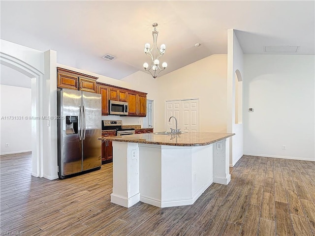 kitchen with sink, wood-type flooring, vaulted ceiling, hanging light fixtures, and appliances with stainless steel finishes