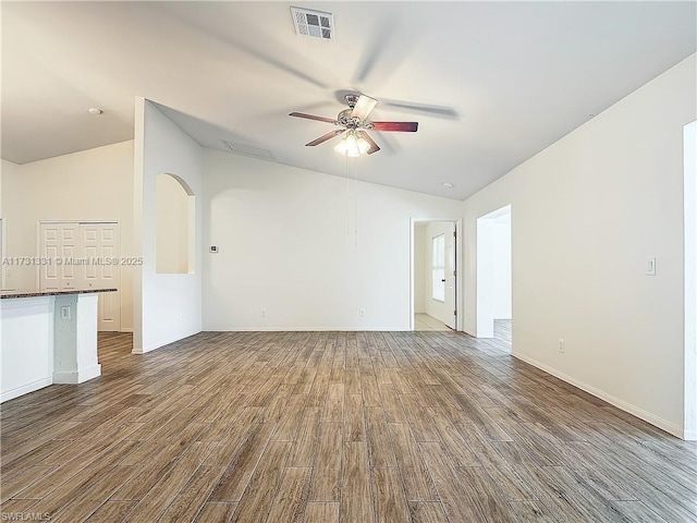 empty room featuring ceiling fan, wood-type flooring, and vaulted ceiling