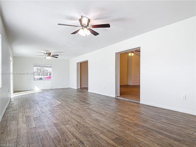 spare room with ceiling fan and dark hardwood / wood-style flooring