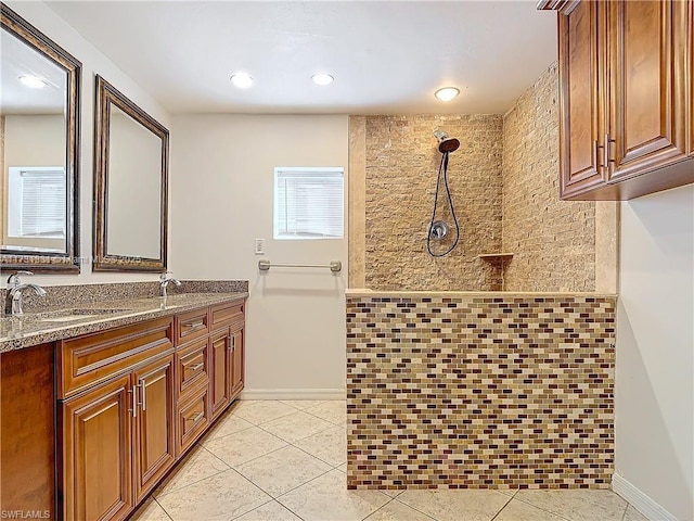 bathroom featuring tile patterned flooring, vanity, and tiled shower