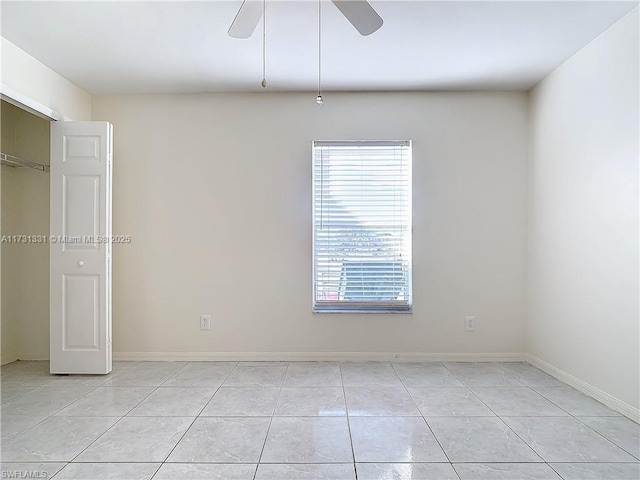 tiled empty room featuring ceiling fan