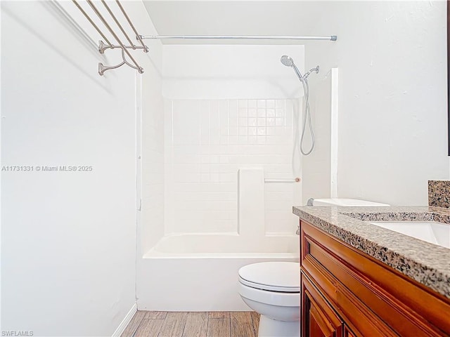 full bathroom featuring vanity, toilet,  shower combination, and hardwood / wood-style floors