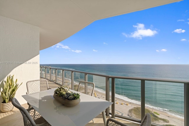 balcony featuring a view of the beach and a water view