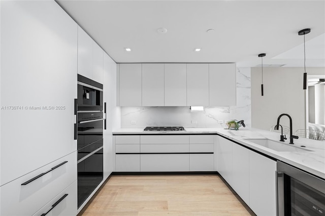 kitchen with beverage cooler, a sink, white cabinetry, modern cabinets, and stainless steel gas stovetop