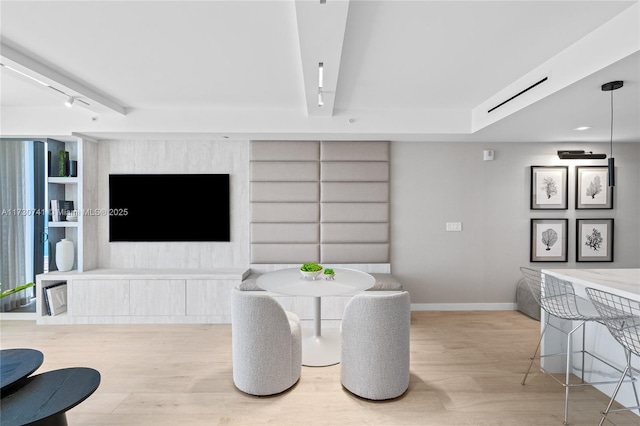 dining area with track lighting, baseboards, and wood finished floors