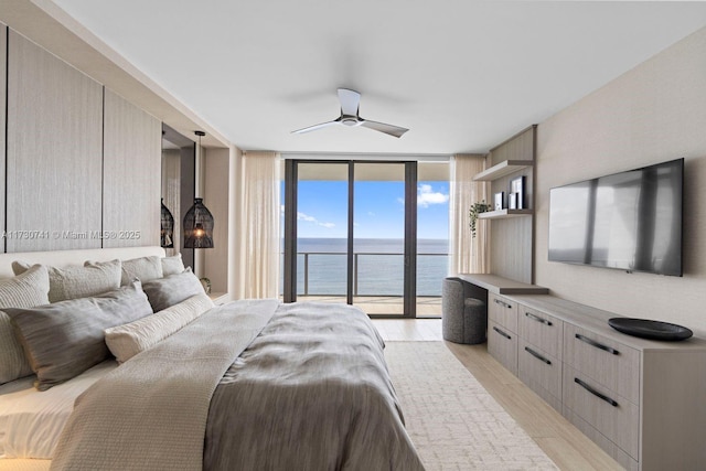 bedroom featuring access to exterior, a wall of windows, ceiling fan, and light wood-type flooring