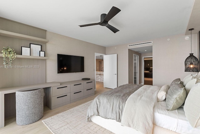 bedroom with connected bathroom, ceiling fan, and light hardwood / wood-style flooring