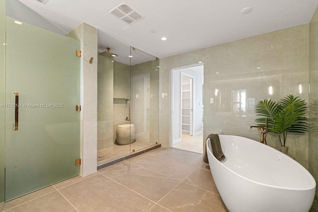 bathroom featuring tile walls, tile patterned flooring, and shower with separate bathtub