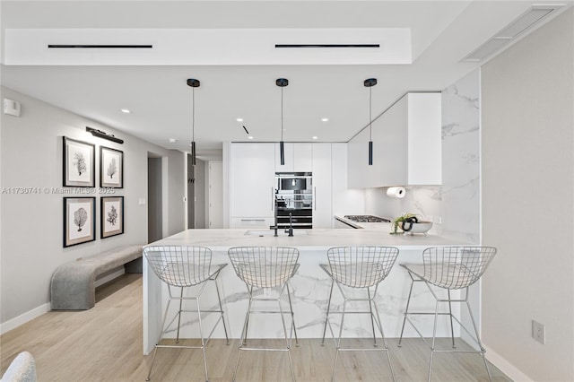 kitchen featuring a peninsula, modern cabinets, a breakfast bar area, and white cabinets