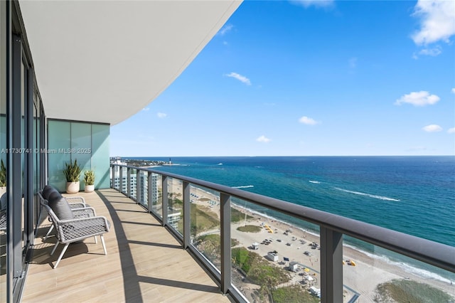 balcony featuring a water view and a beach view