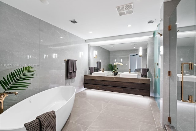 bathroom featuring a sink, visible vents, and tile walls