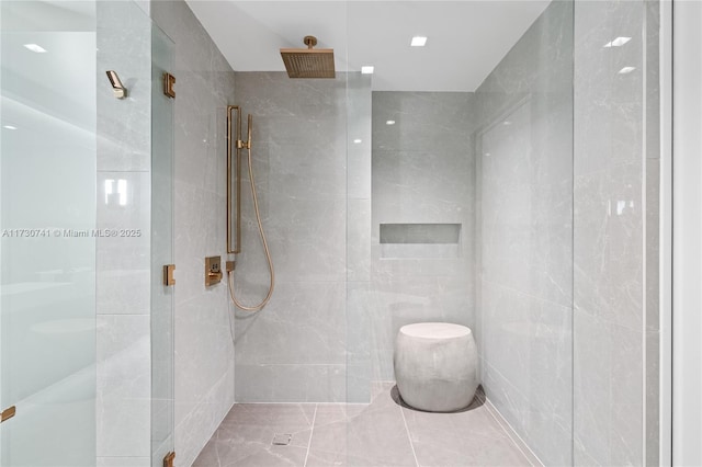 full bathroom featuring a stall shower and tile walls