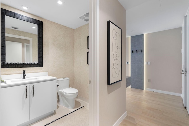 bathroom featuring hardwood / wood-style flooring, vanity, and toilet