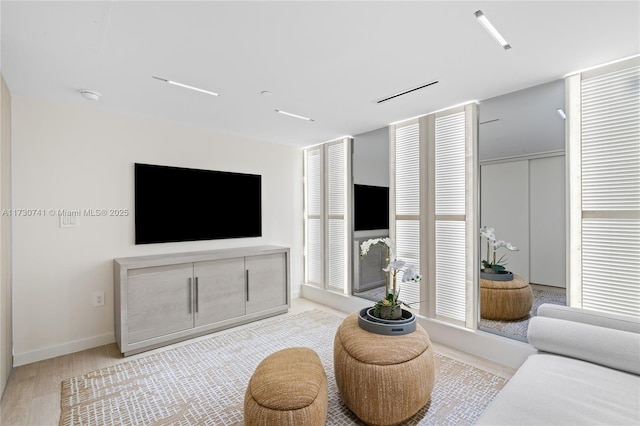 living area with baseboards and wood finished floors