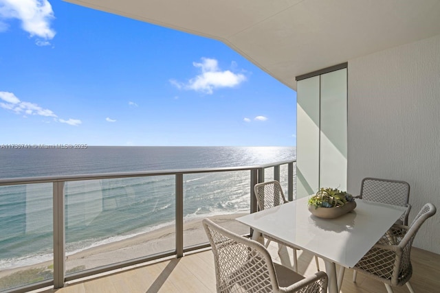 balcony featuring a water view and a beach view