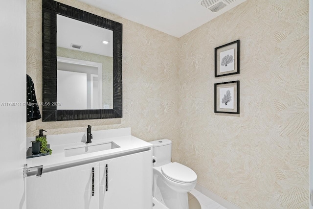 half bathroom featuring visible vents, vanity, toilet, and wallpapered walls