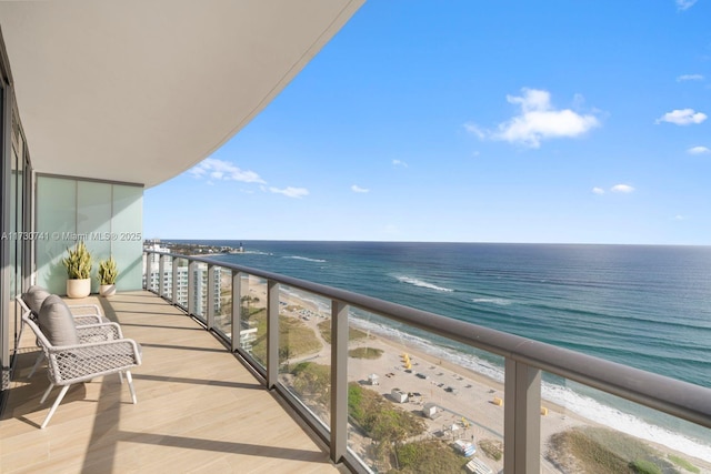 balcony featuring a water view and a beach view