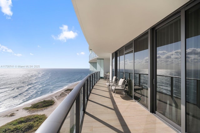 balcony with a water view and a beach view