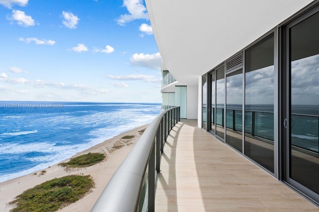 balcony featuring a water view and a view of the beach