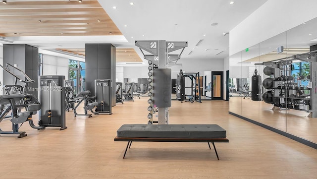 exercise room with wooden ceiling and light wood-type flooring