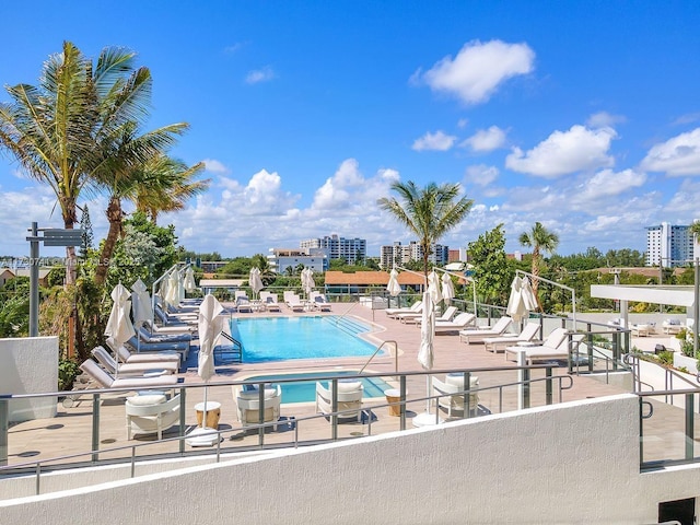 pool with a patio area and a city view