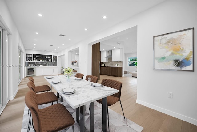 dining room featuring wine cooler and light hardwood / wood-style floors