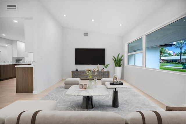 living room featuring vaulted ceiling and light wood-type flooring